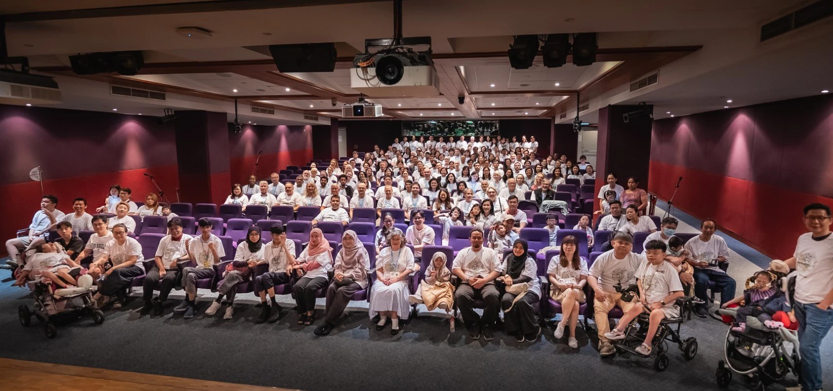 Group photo of the collaborators, People Living With Undiagnosed Diseases and their families in an auditorium at the 5th Undiagnosed Hackathon in Singapore, September 2026